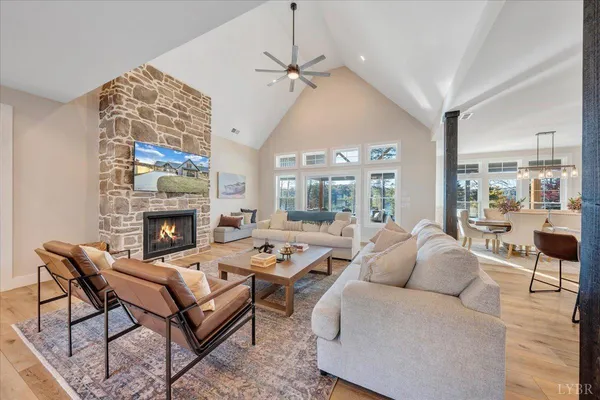 a kitchen with stainless steel appliances granite countertop a stove top oven a sink dishwasher and a dining table with wooden floor