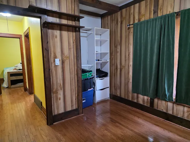 a view of a hallway with wooden floor and staircase