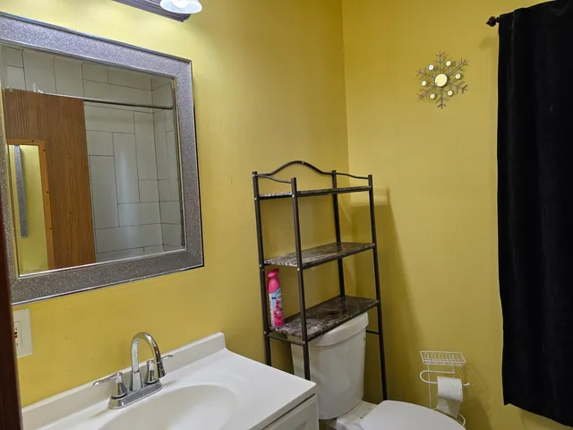 a bathroom with a sink and mirror with toilet