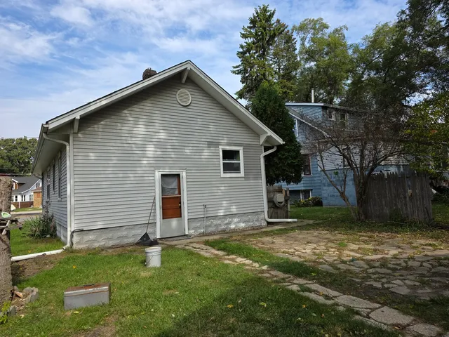 a front view of house with yard and trees all around