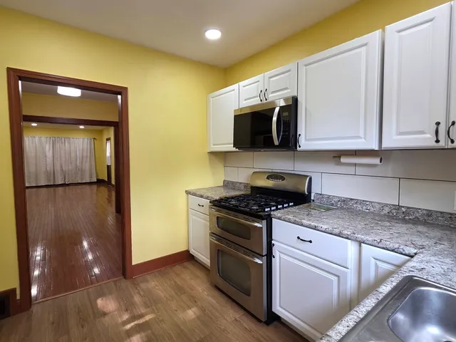 a kitchen with stainless steel appliances granite countertop a stove a sink and a microwave