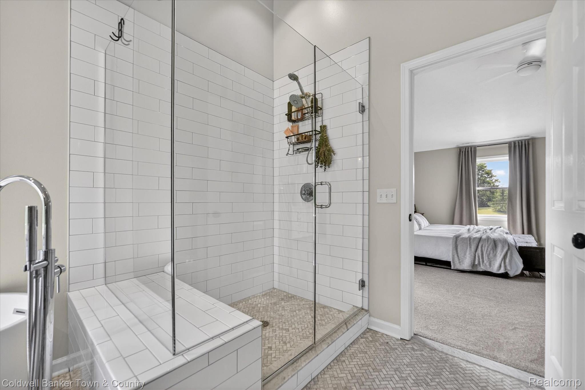 918 Gray Fox Court Howell, MI 48843 - Photo 34 of 84 Glass-enclosed shower with white subway tile surround, integrated bench, and herringbone pattern floor tile
