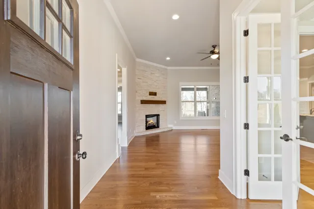 a kitchen with stainless steel appliances a stove top oven a sink dishwasher and a refrigerator with wooden floor