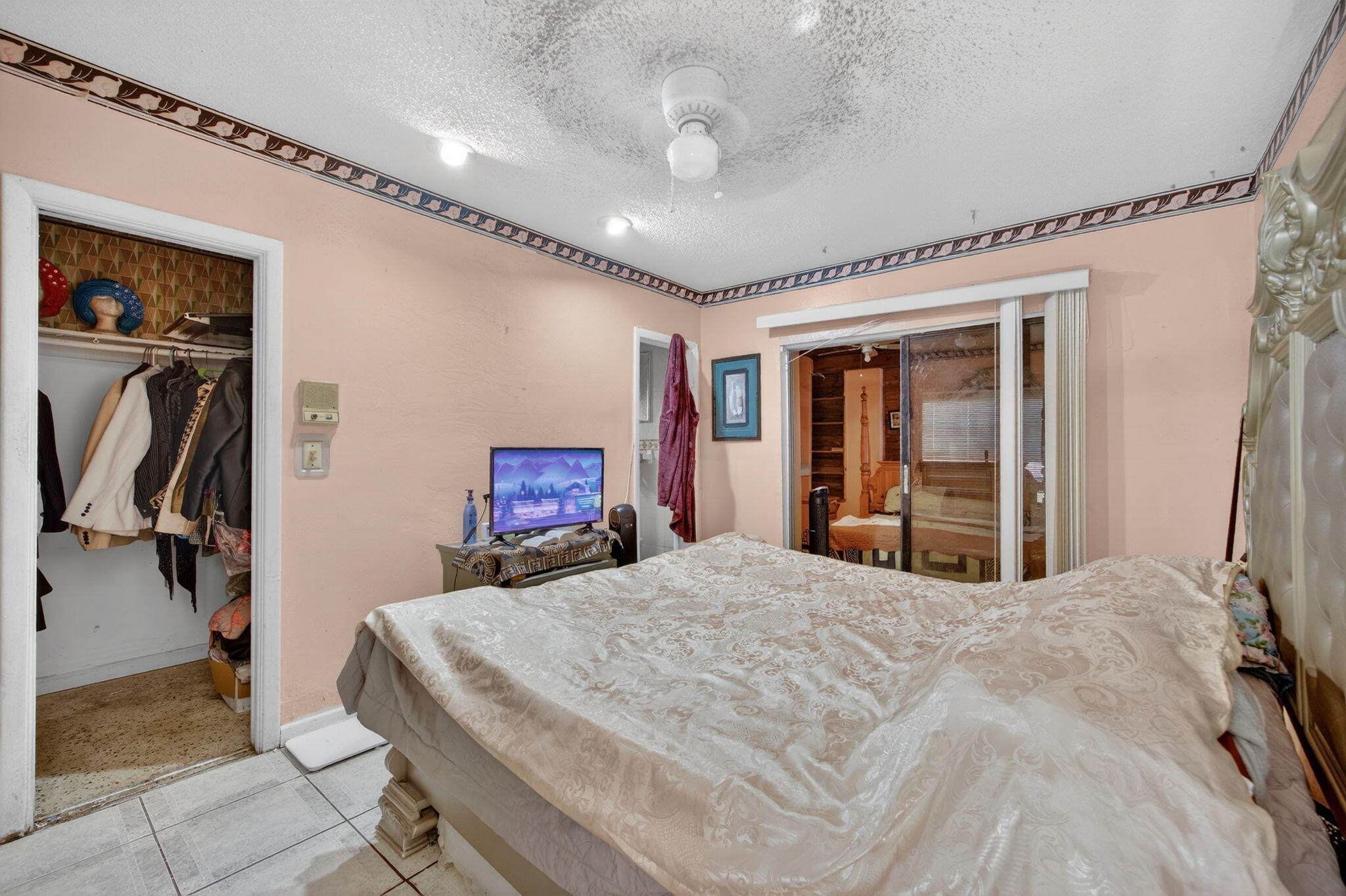 9281 Martinique Drive Miami, FL 33189 - Photo 19 of 35 a bedroom with a large bed and a chandelier