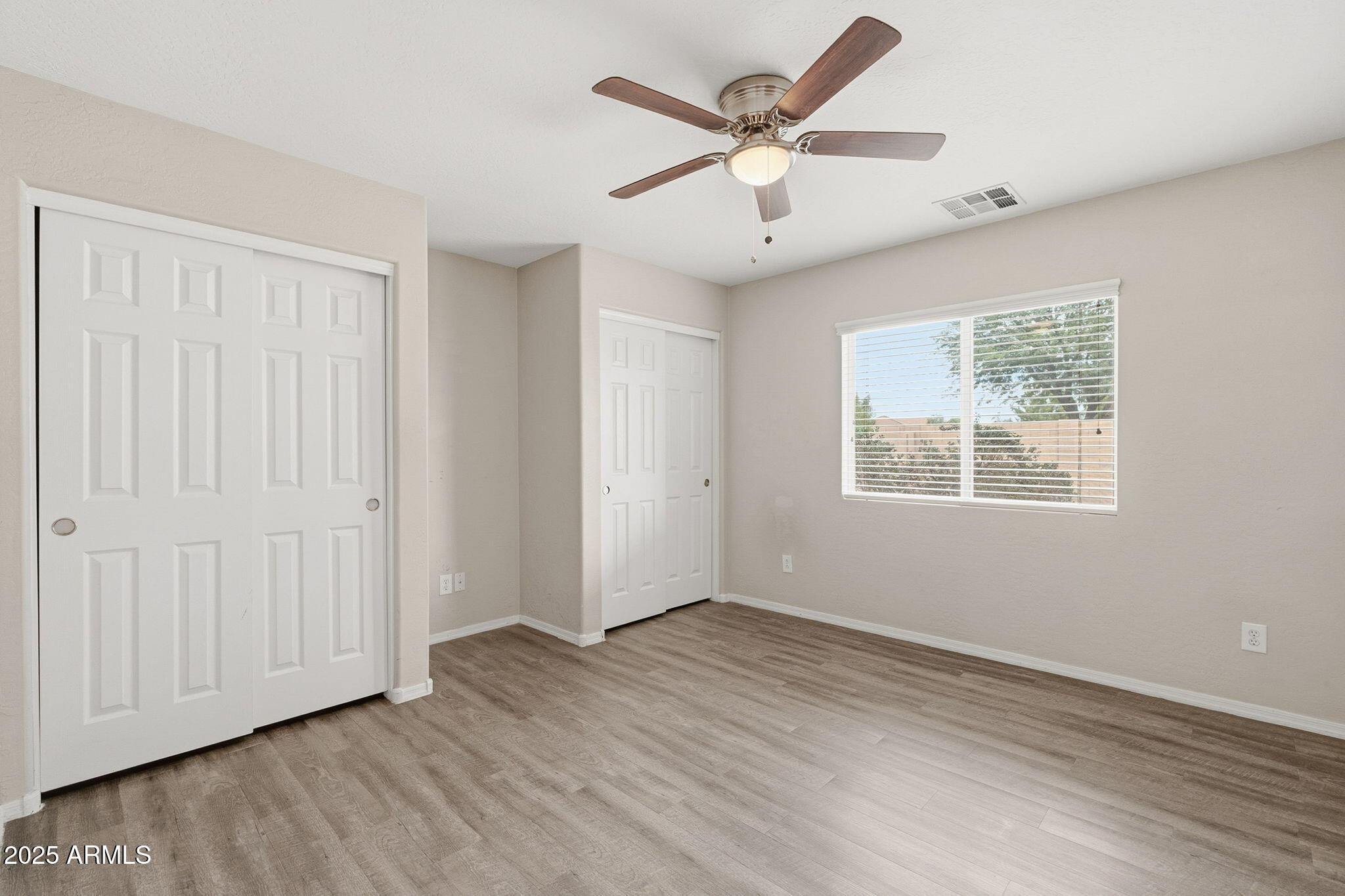 227 South 16th Street Coolidge, AZ 85128 - Photo 18 of 34 an empty room with wooden floor ceiling fan and windows
