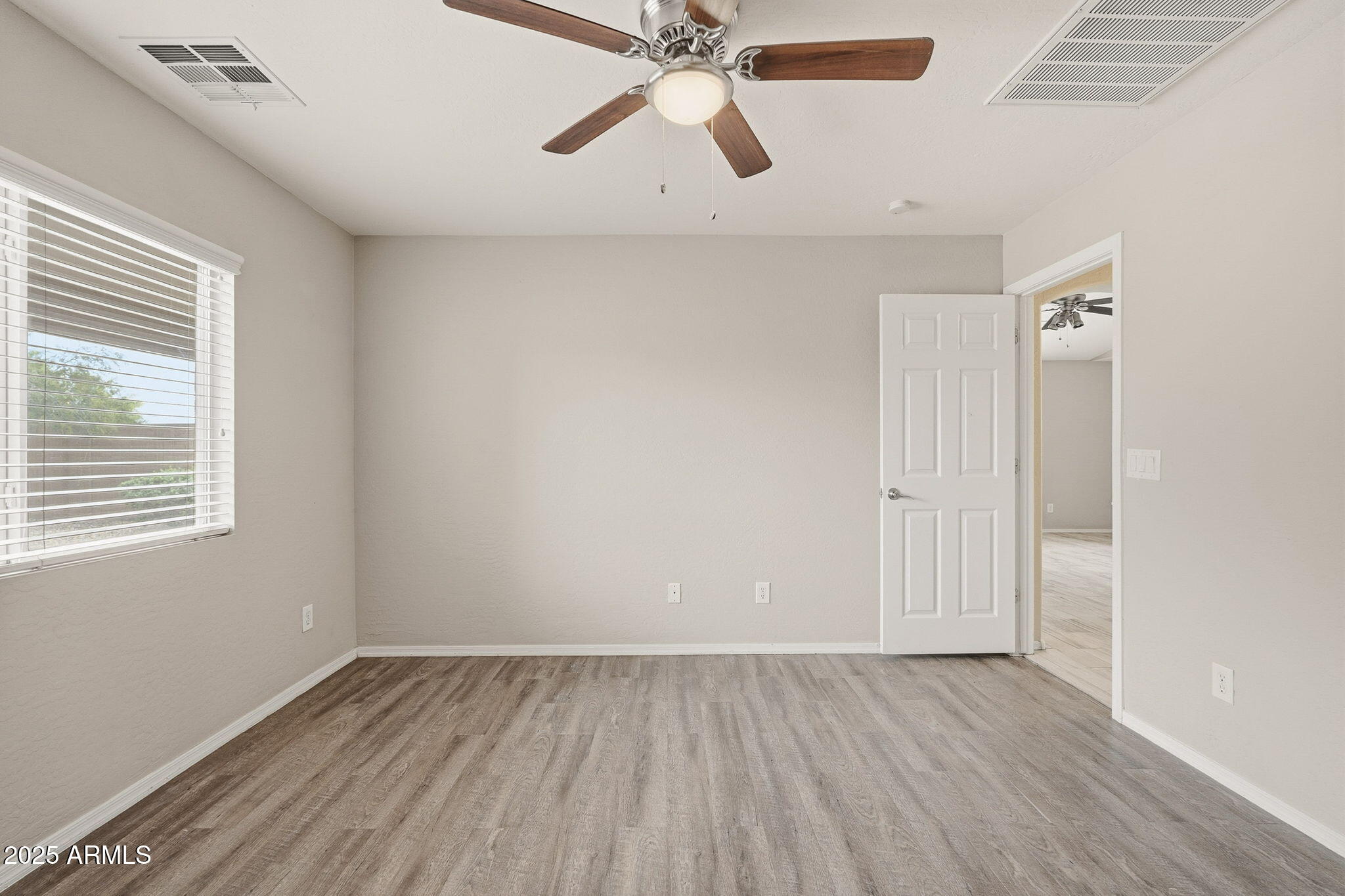 227 South 16th Street Coolidge, AZ 85128 - Photo 20 of 34 a view of an empty room with wooden floor and a window