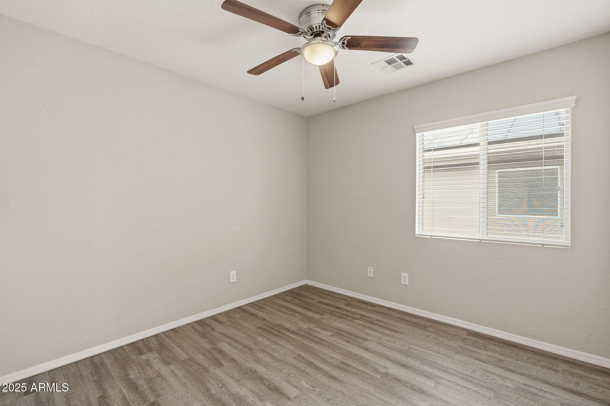 227 South 16th Street Coolidge, AZ 85128 - Photo 22 of 34 an empty room with a window and a ceiling fan