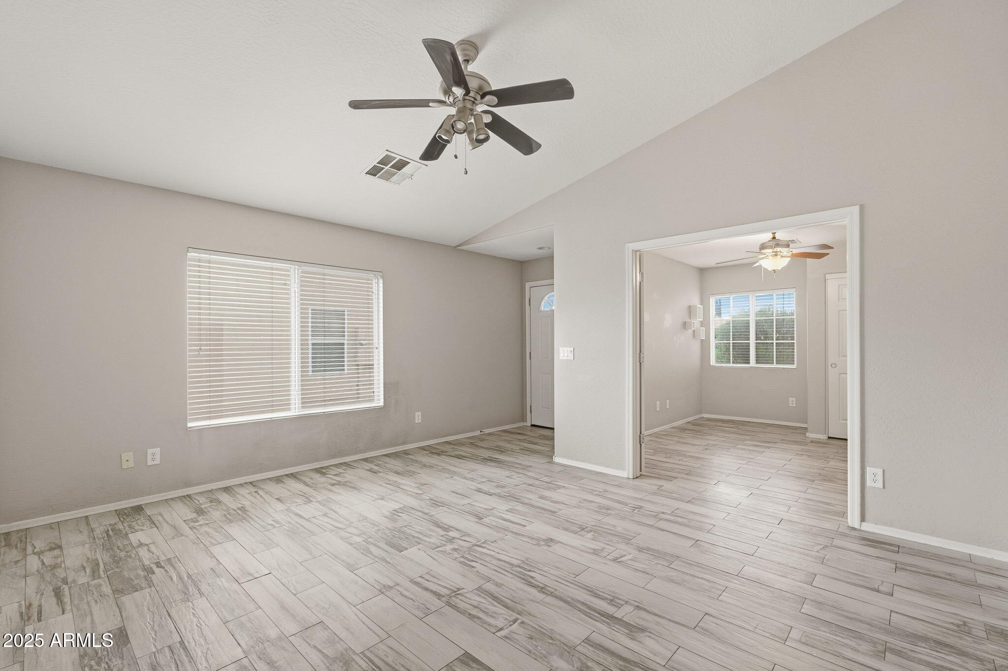227 South 16th Street Coolidge, AZ 85128 - Photo 8 of 34 an empty room with wooden floor chandelier fan and windows