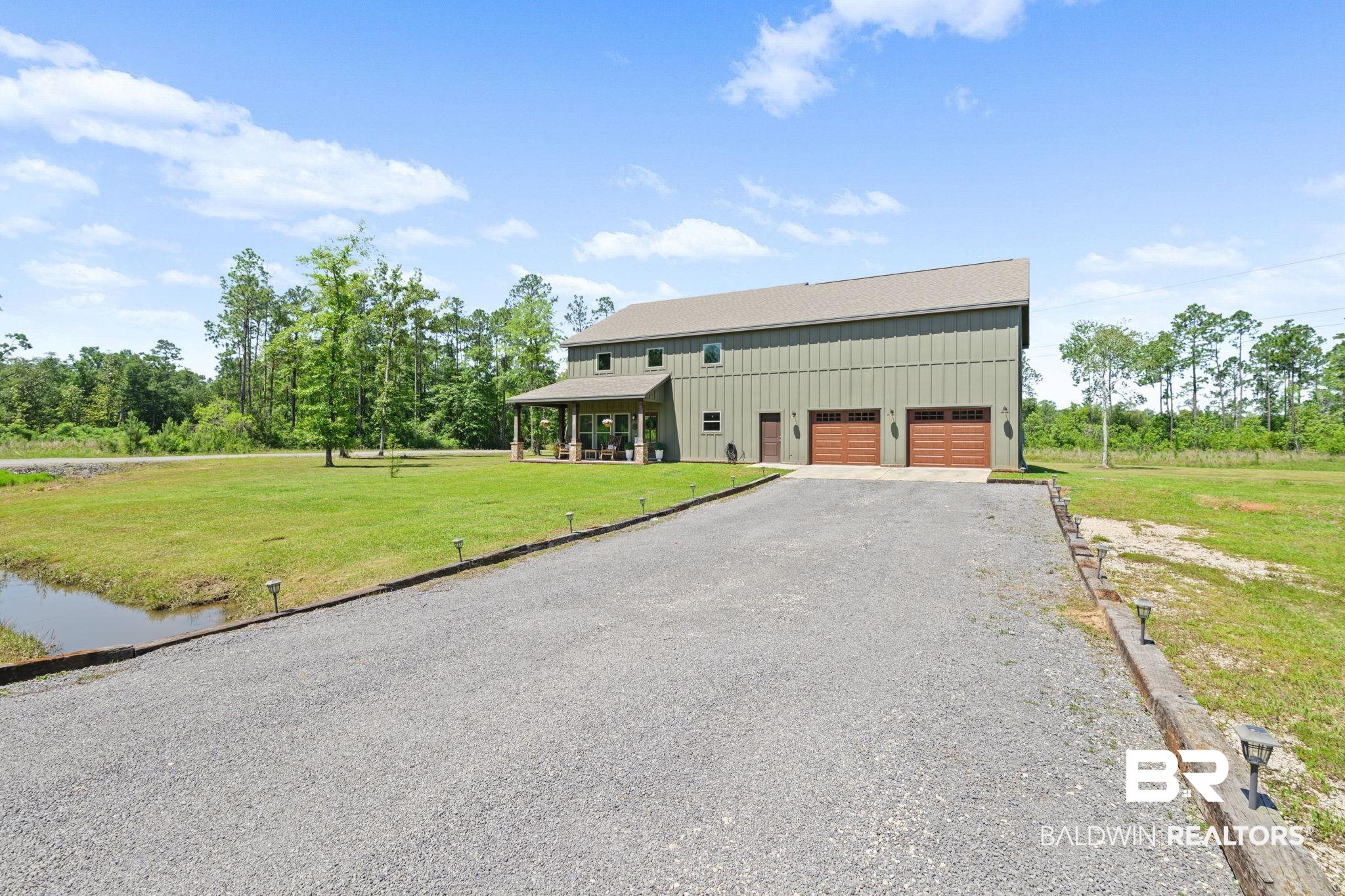 11025 Creax Road Axis, AL 36505 - Photo 1 of 45 Two-story property featuring a deep green metal siding exterior and a light gray roof
