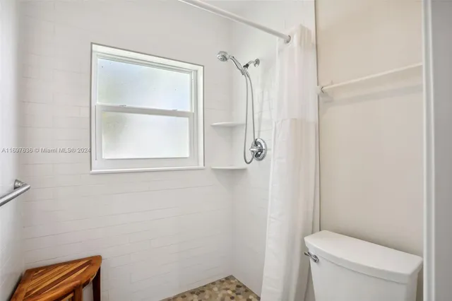 a bathroom with a toilet and a shower curtain