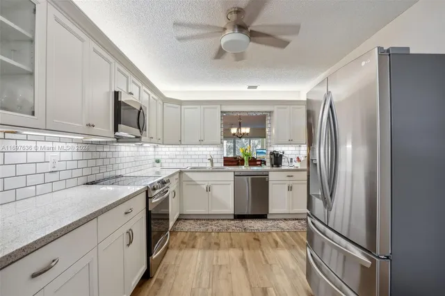 a kitchen with a refrigerator sink and cabinets