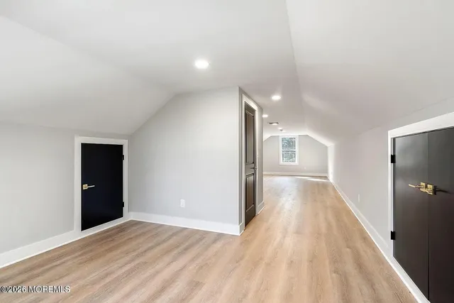a view of a hallway with wooden floor and closet