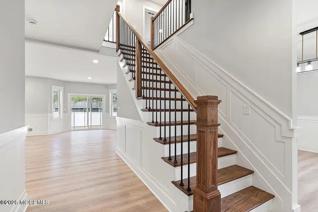 a view of staircase with wooden floor and white walls