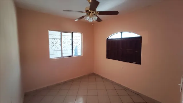 a view of a livingroom with a chandelier fan and windows
