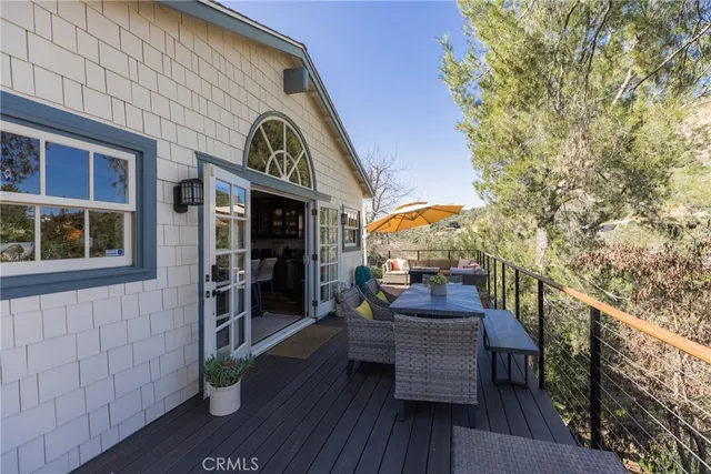 a view of a roof deck with table and chairs with wooden floor and fence