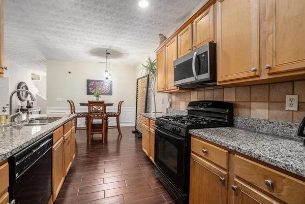a kitchen with stainless steel appliances granite countertop a stove a sink and a microwave