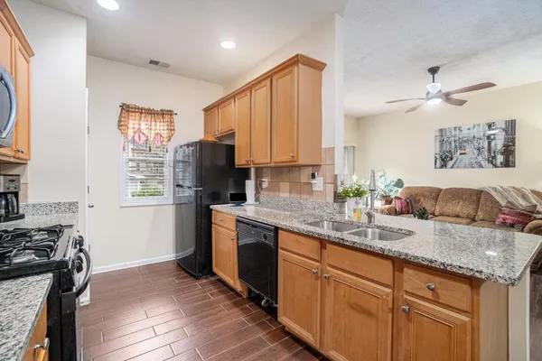 a kitchen with granite countertop kitchen island stainless steel appliances a refrigerator sink and stove