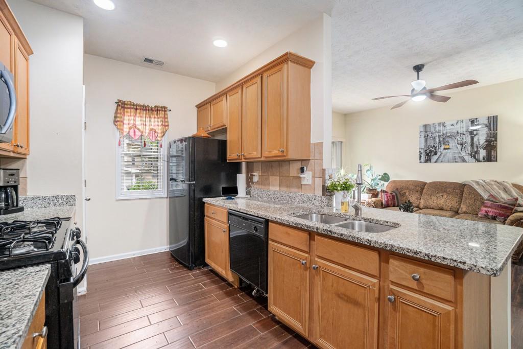 771 Nehemiah Lane Atlanta, GA 30331 - Photo 14 of 30 a kitchen with granite countertop kitchen island stainless steel appliances a refrigerator sink and stove