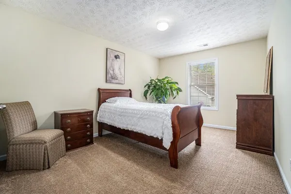 a bedroom with a bed and dresser with mirror