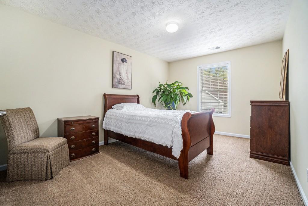 771 Nehemiah Lane Atlanta, GA 30331 - Photo 21 of 30 a bedroom with a bed and dresser with mirror