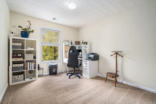 a view of a workspace with furniture and a window