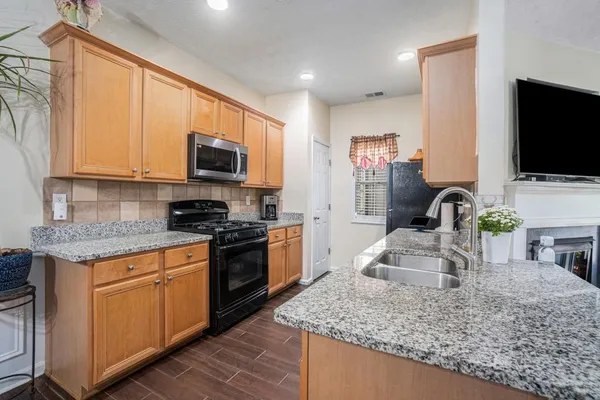 a kitchen with granite countertop a sink and a stove top oven
