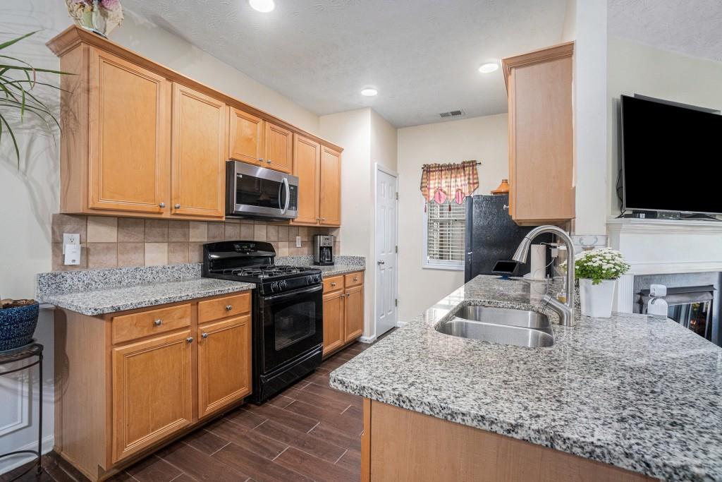 771 Nehemiah Lane Atlanta, GA 30331 - Photo 3 of 30 a kitchen with granite countertop a sink and a stove top oven