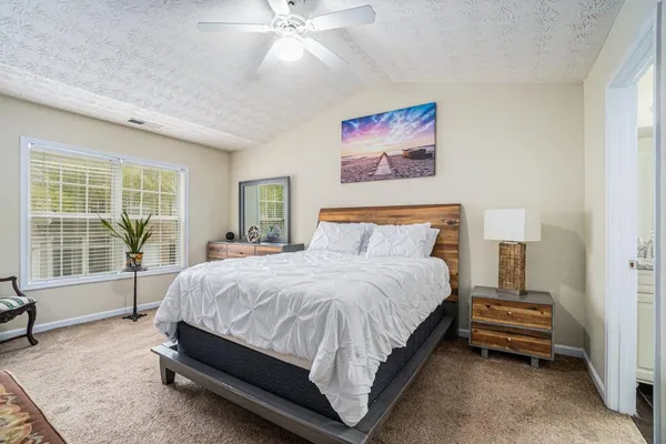 a spacious bedroom with a bed and a large window