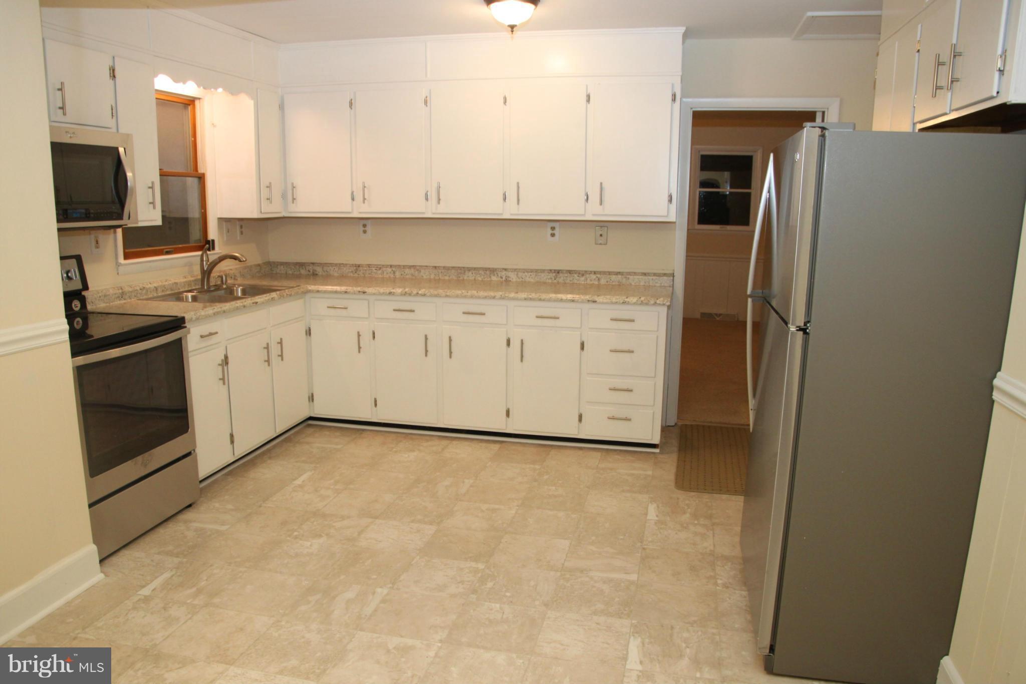 12409 Big Spring Road Clear Spring, MD 21722 - Photo 16 of 20 a kitchen with granite countertop white cabinets and stainless steel appliances