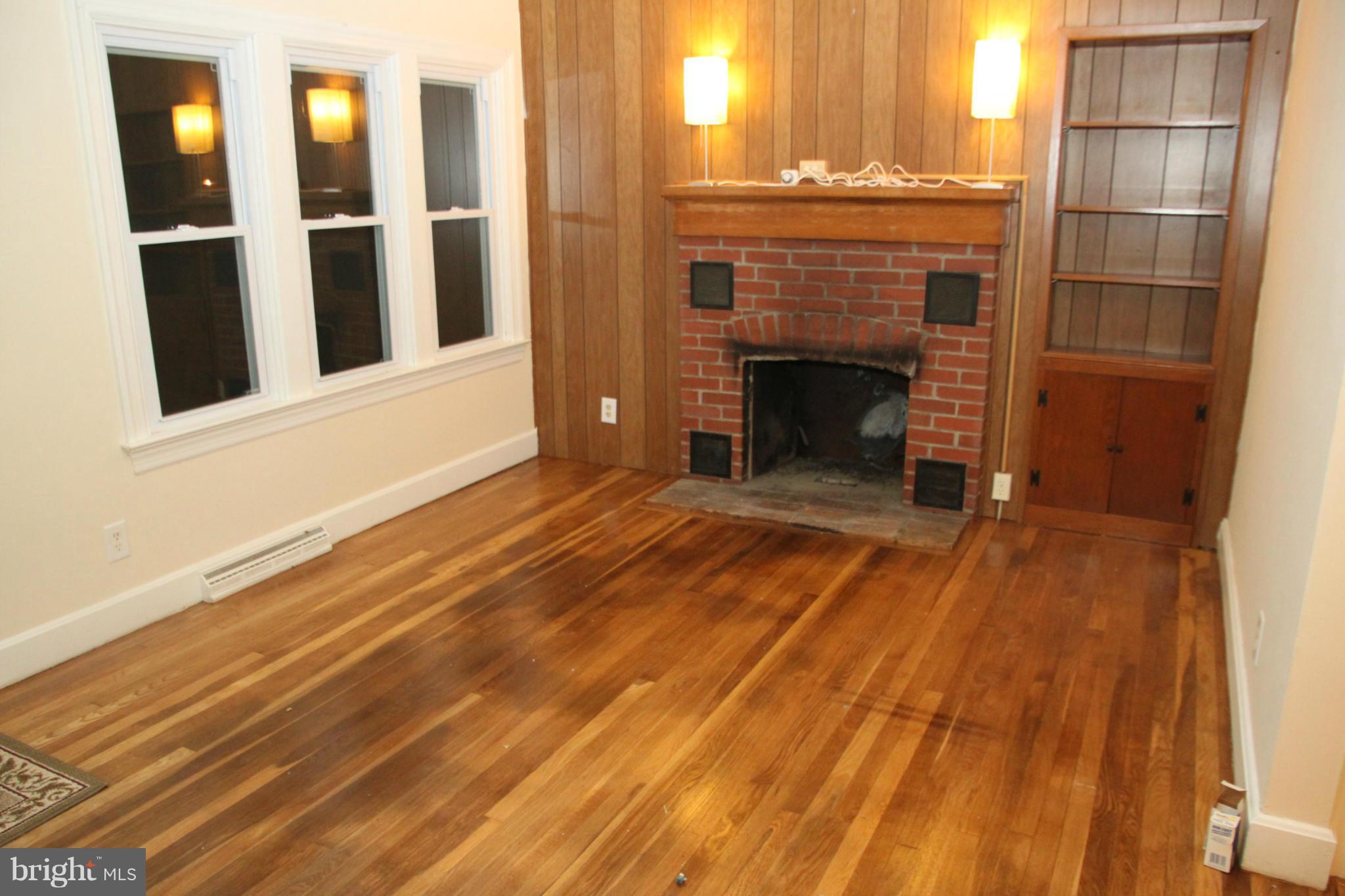 12409 Big Spring Road Clear Spring, MD 21722 - Photo 8 of 20 a view of an empty room with wooden floor and a fireplace