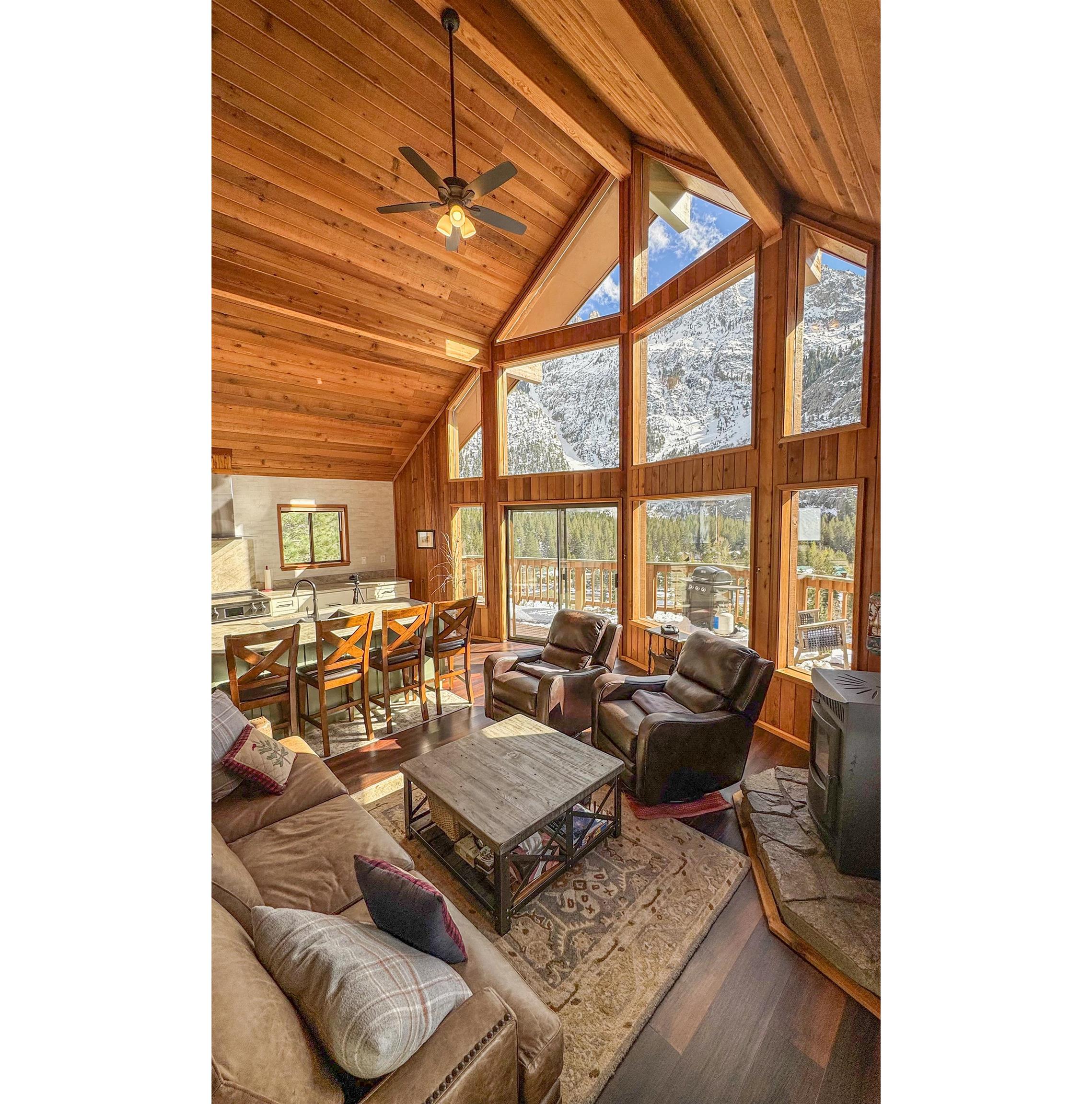 179 Washington Street June Lake, CA 93529 - Photo 4 of 49 Living area with a high wooden beamed ceiling, wood finished floors, a ceiling fan, a pellet stove