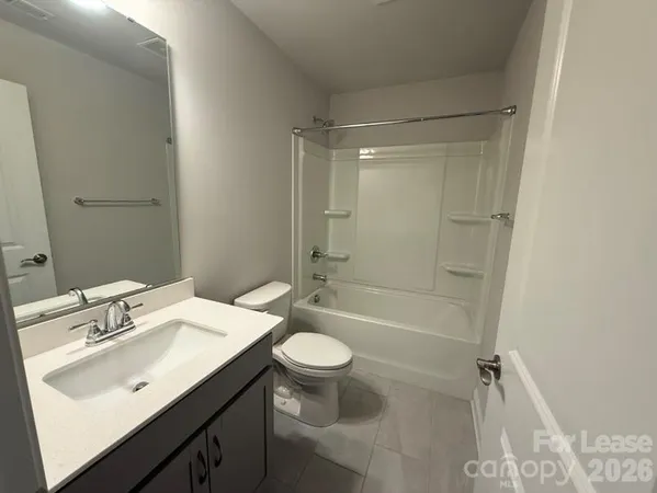 a bathroom with a sink a toilet a mirror and shower