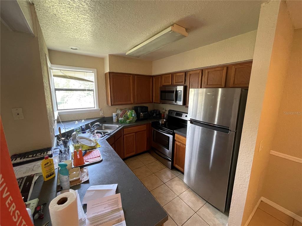 3044 Antique Oaks Circle, Unit 178 Winter Park, FL 32792 - Photo 8 of 9 a kitchen with refrigerator a microwave a sink and cabinets