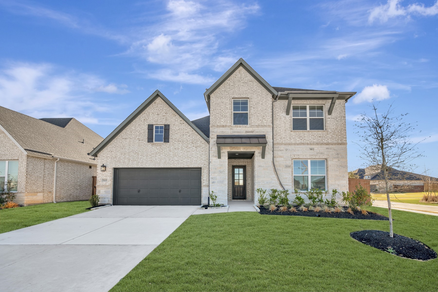 a front view of a house with a yard and garage