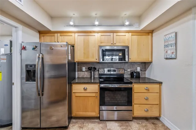 a kitchen with stainless steel appliances granite countertop a refrigerator and a stove top oven