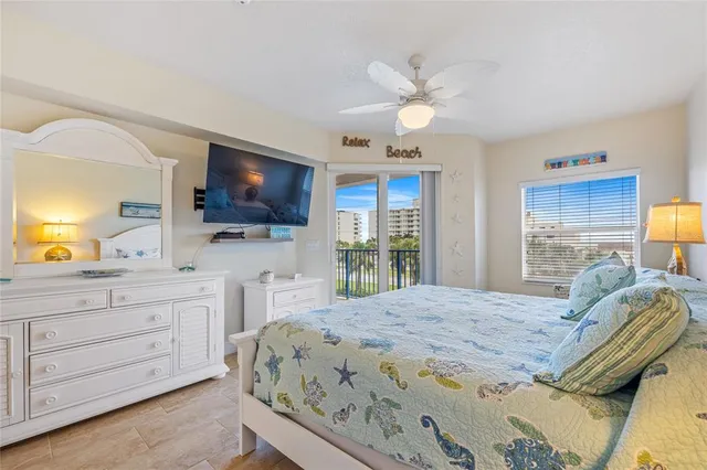 a bedroom with a large bed and a flat tv screen on dresser