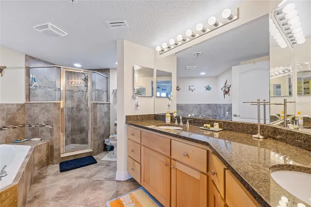 a spacious bathroom with a granite countertop sink mirror and shower