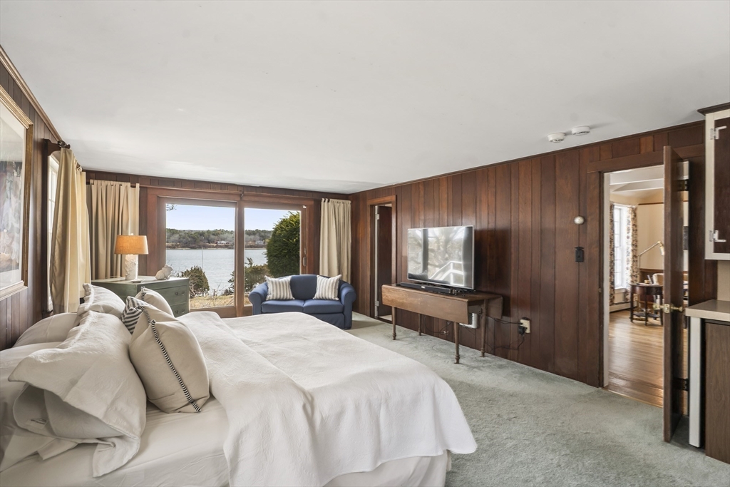 94 Weaver Lane Tisbury, MA 02568 - Photo 19 of 36 a bedroom with a bed and large windows