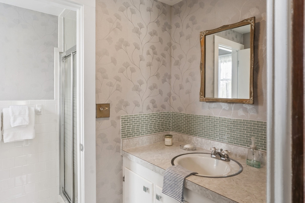 94 Weaver Lane Tisbury, MA 02568 - Photo 21 of 36 a bathroom with a sink a mirror and a bathtub