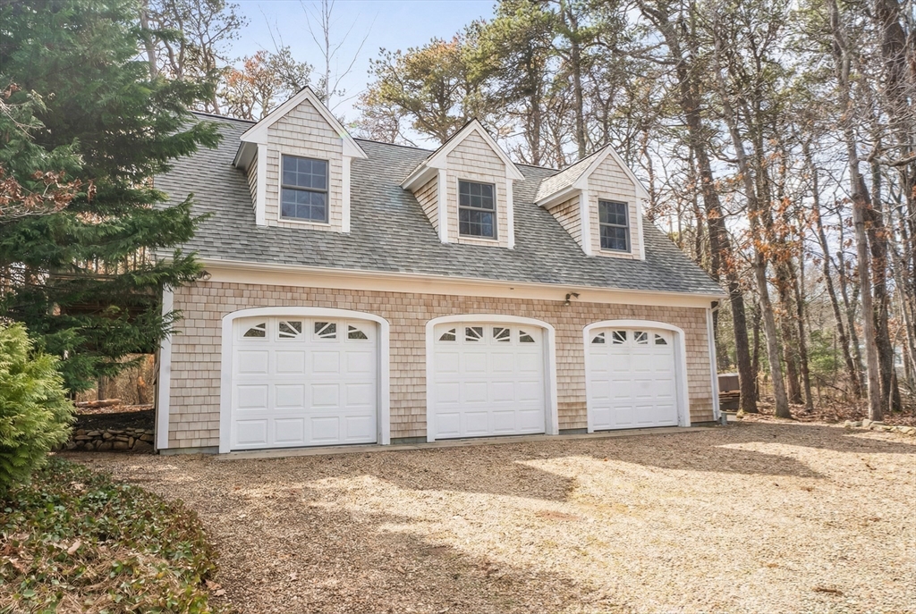 94 Weaver Lane Tisbury, MA 02568 - Photo 31 of 36 a front view of a house with a yard and garage
