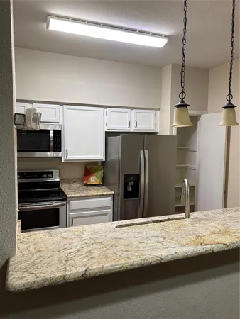 a view of a kitchen counter space and a refrigerator