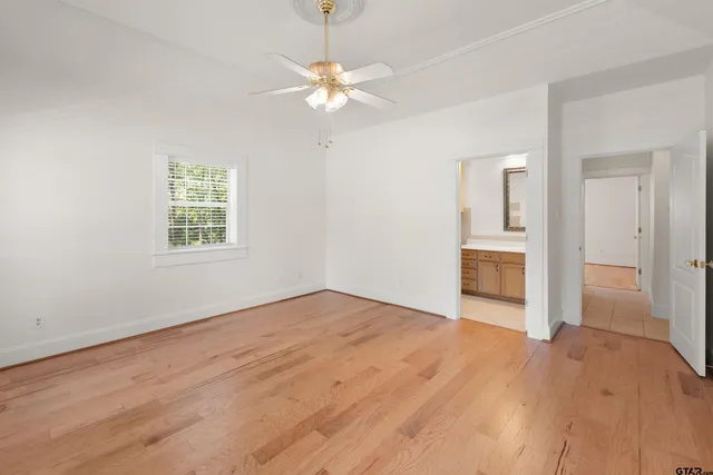 an empty room with fan and windows