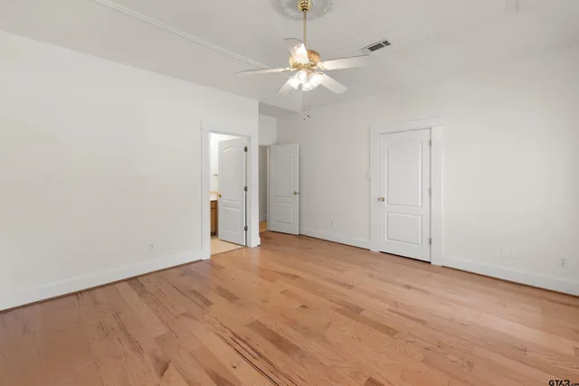 a view of an empty room with wooden floor
