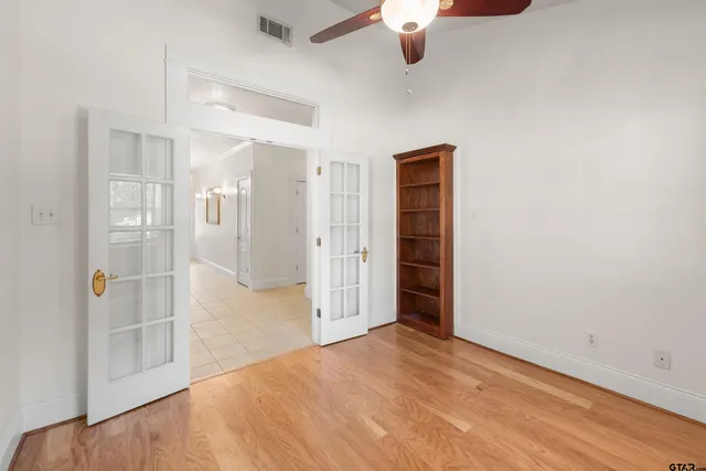 an empty room with fan and entrance