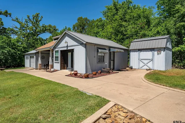 a view of a house with a patio and a yard