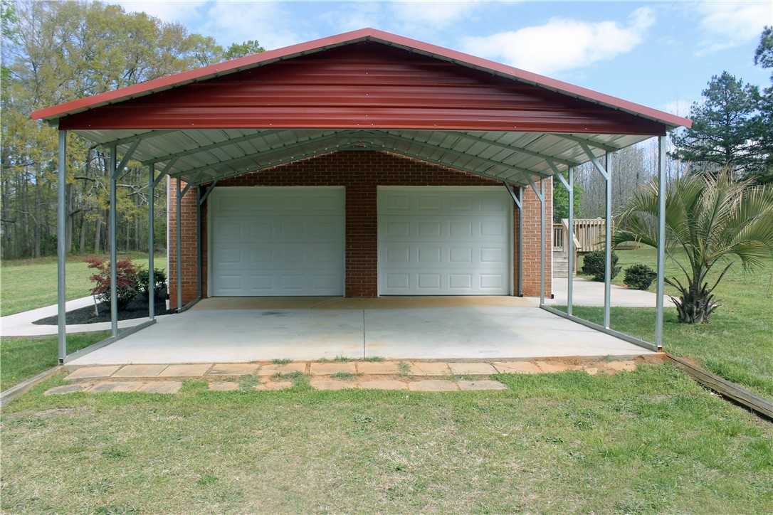 1007 O Neal Street Belton, SC 29627 - Photo 5 of 25 This structure features a robust carport providing ample sheltered parking for vehicles.