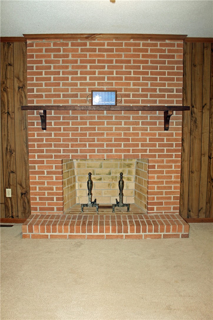 1007 O Neal Street Belton, SC 29627 - Photo 7 of 25 This living room features a classic brick fireplace, creating a cozy and inviting atmosphere.