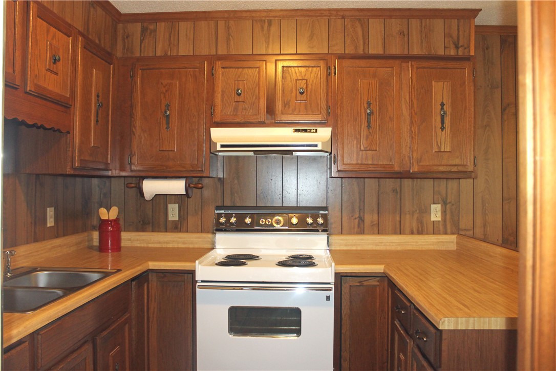 1007 O Neal Street Belton, SC 29627 - Photo 8 of 25 This cozy kitchen features a classic aesthetic with ample cabinetry and essential cooking appliances.