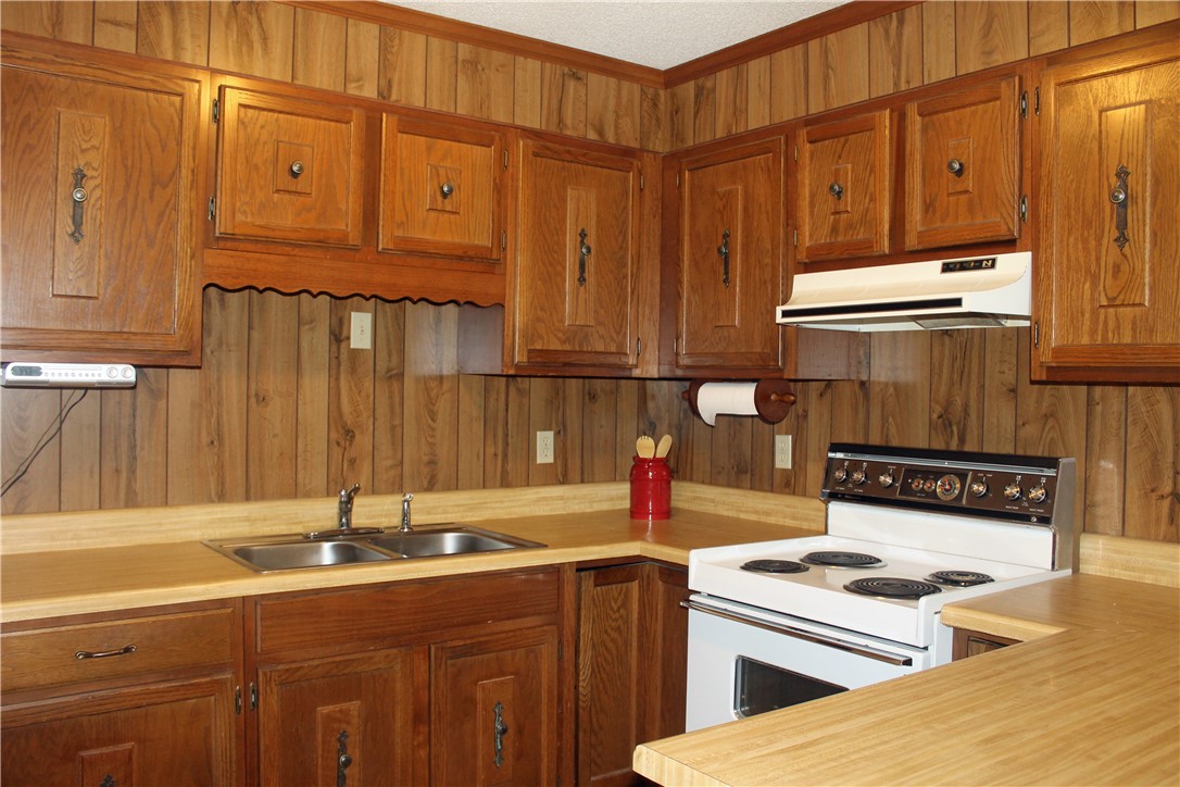 1007 O Neal Street Belton, SC 29627 - Photo 10 of 25 This cozy kitchen features abundant wood cabinetry and functional appliances, perfect for everyday living.