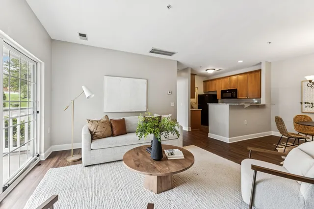 a living room with furniture and a dining table with kitchen view
